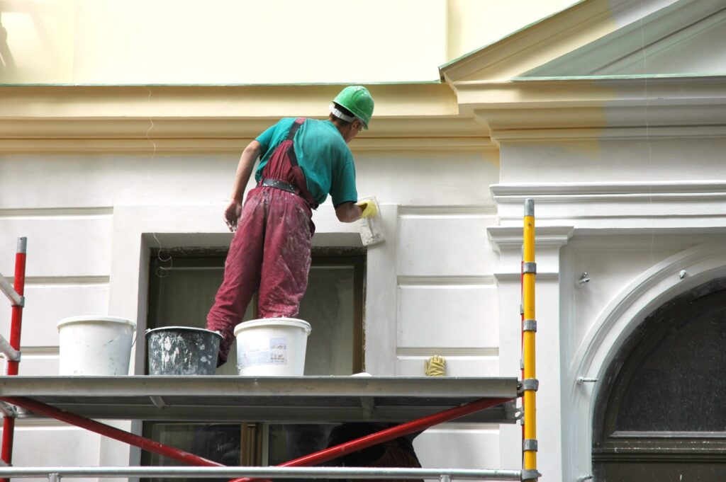 house painter on scaffolding working on a new paint job