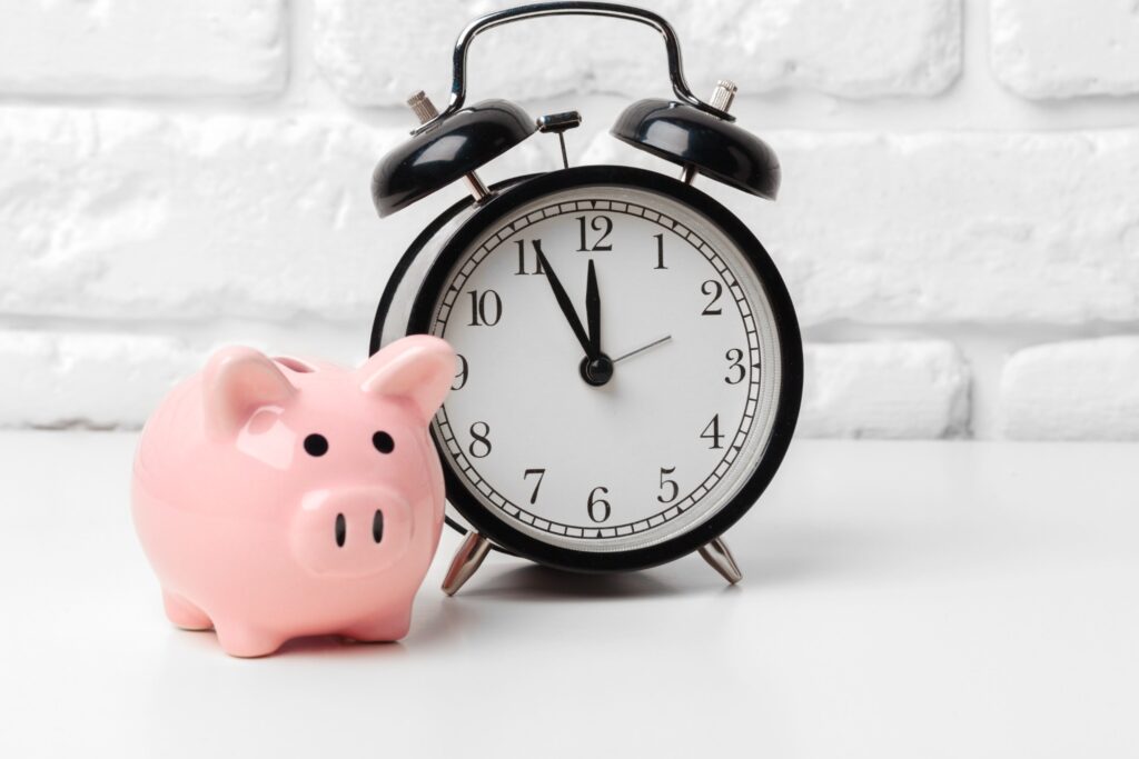 Image of a piggy bank and an alarm clock to convey concept of time and money