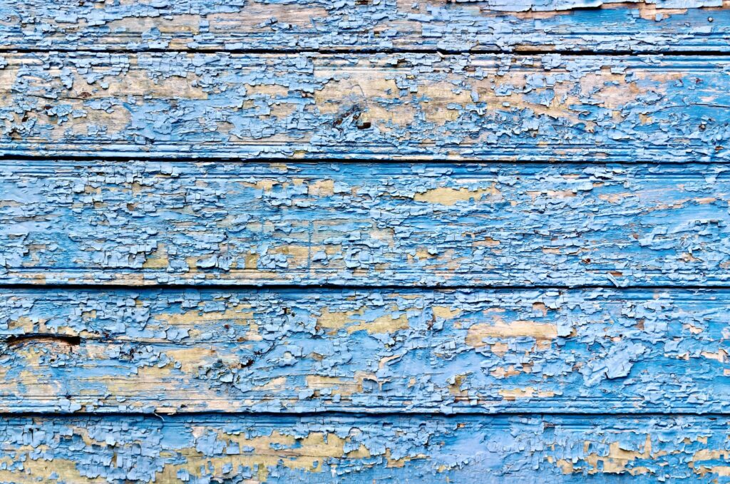 Image of cracked, peeling paint on wood siding.
