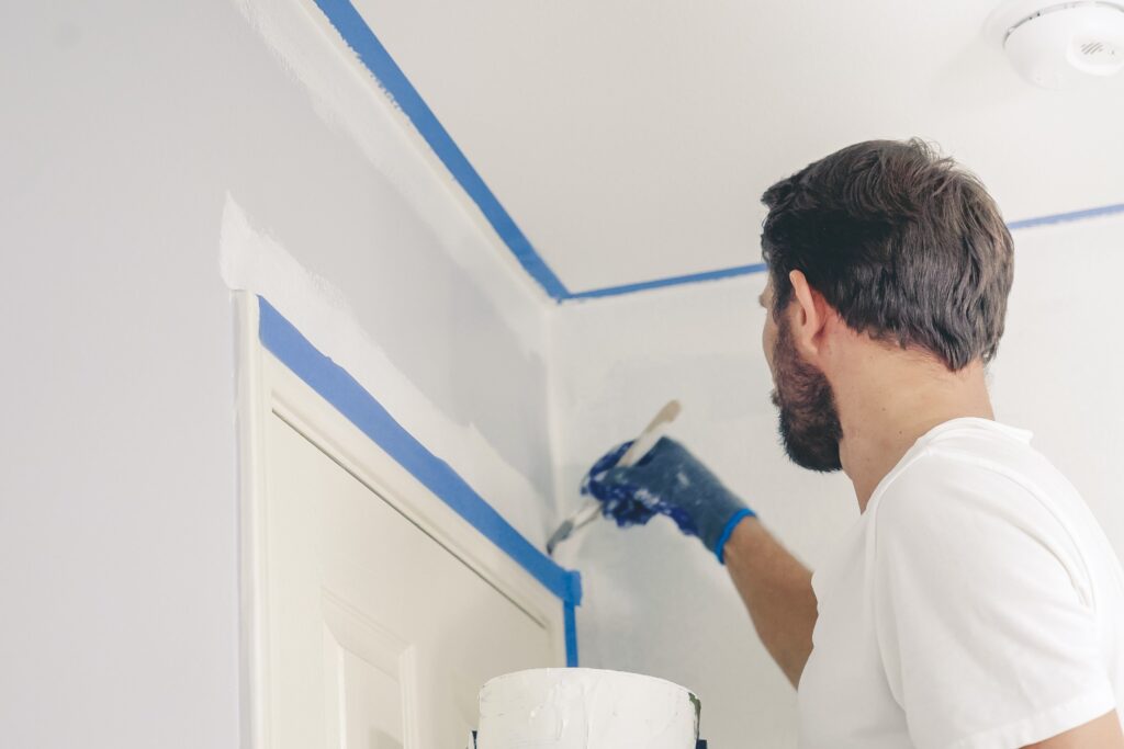 Image of man painting edges and corners of walls