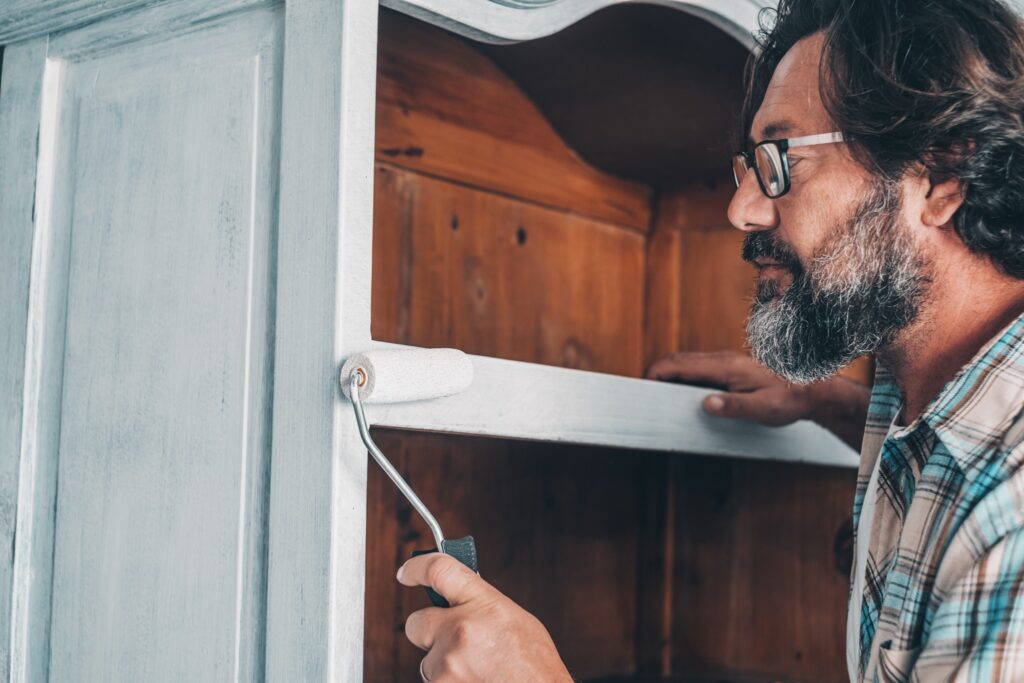 Image of man painting cabinet