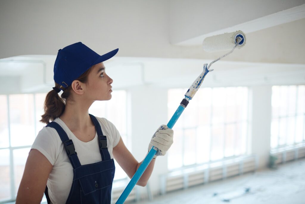 Image of a woman painting a ceiling.