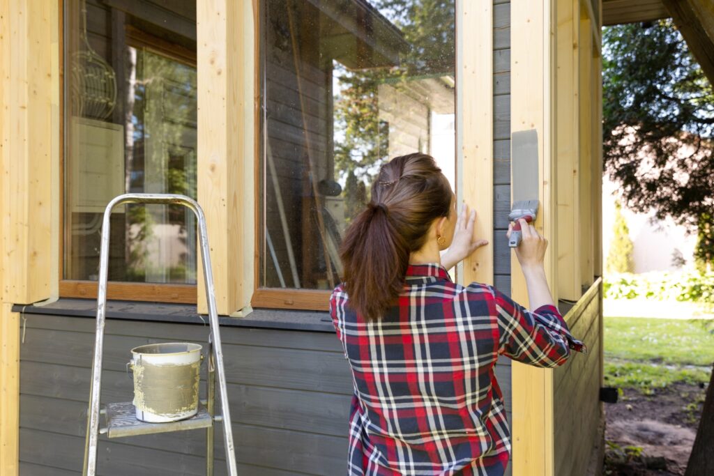 Image of a woman painting the outside of her house