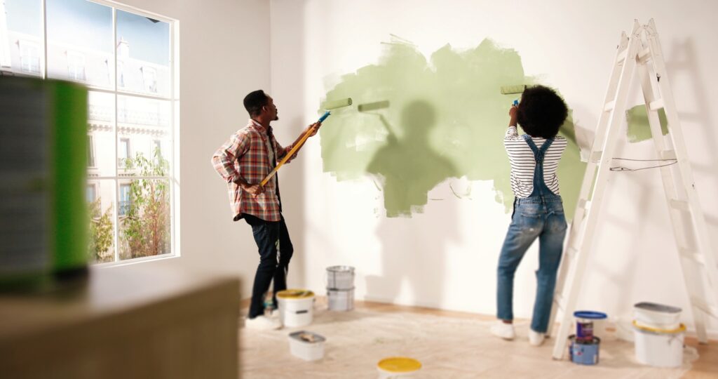 Image of couple painting room with green paint.